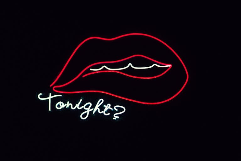 Creative neon sign featuring lips and 'Tonight?' on a black background.